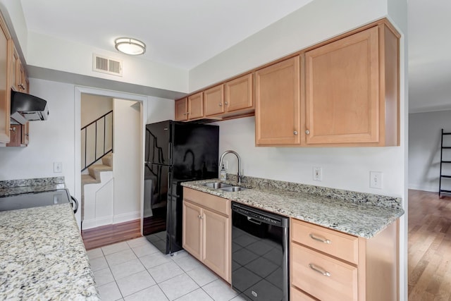 kitchen featuring light stone countertops, sink, light brown cabinetry, light tile patterned floors, and black appliances