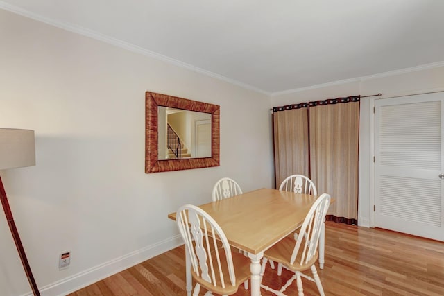 dining room with light hardwood / wood-style floors and ornamental molding