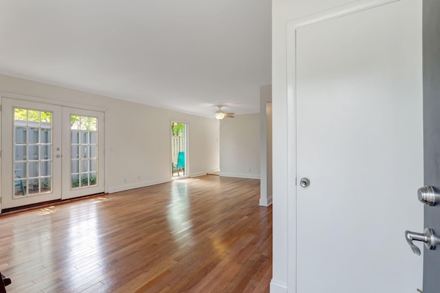 empty room with ceiling fan, french doors, and hardwood / wood-style floors