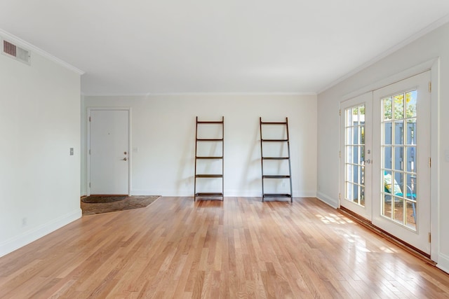 empty room with light hardwood / wood-style flooring, crown molding, and french doors