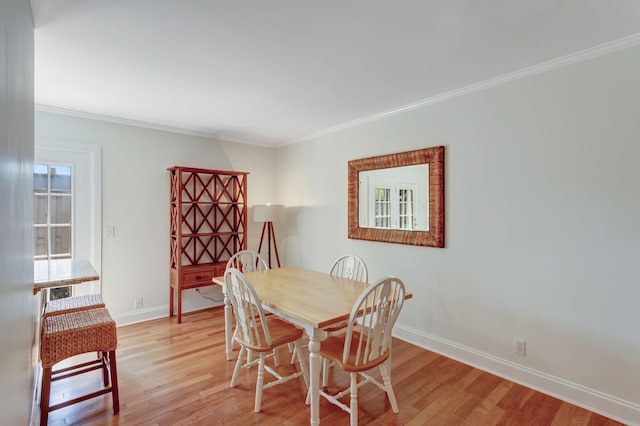 dining room featuring light hardwood / wood-style flooring and ornamental molding