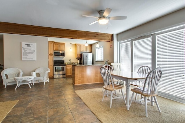 dining room with ceiling fan, sink, and beamed ceiling