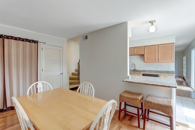 dining space featuring sink and light hardwood / wood-style flooring