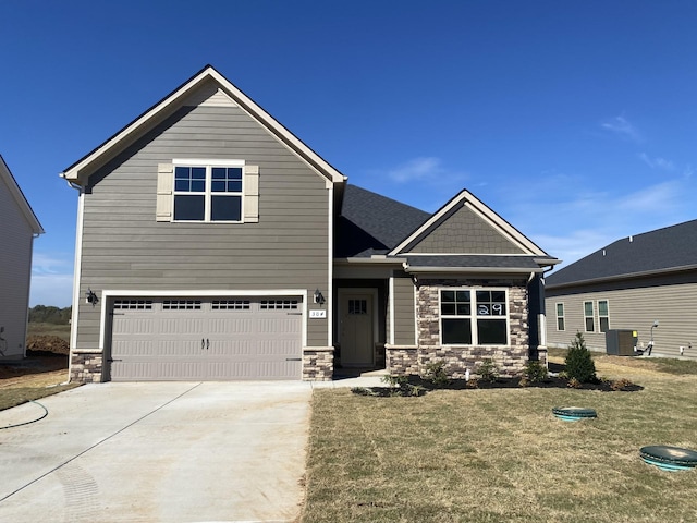 craftsman house with central air condition unit, a front lawn, and a garage