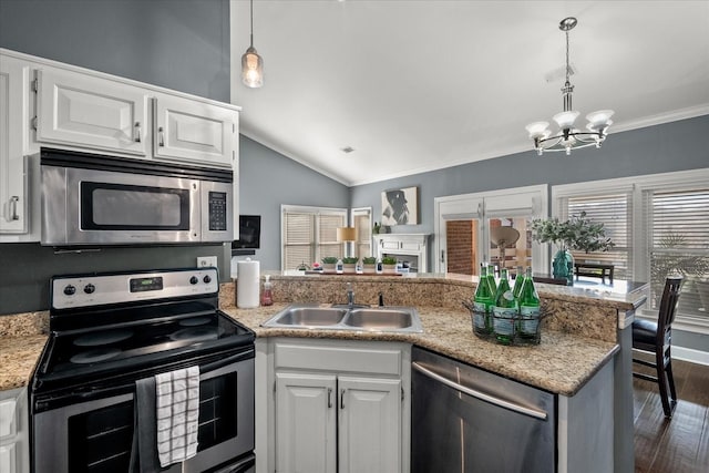 kitchen with sink, appliances with stainless steel finishes, decorative light fixtures, white cabinetry, and a chandelier