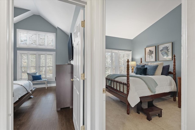 bedroom featuring wood-type flooring, multiple windows, and lofted ceiling