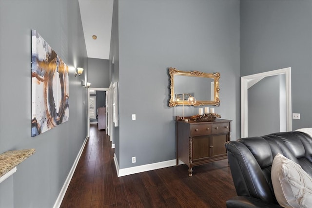 corridor featuring dark hardwood / wood-style flooring and a towering ceiling