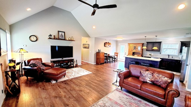 living room with ceiling fan, sink, wood-type flooring, and a healthy amount of sunlight