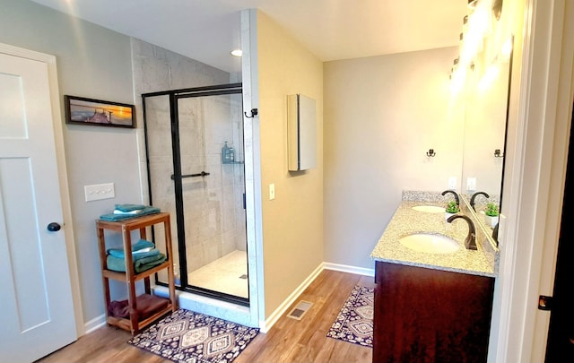 bathroom featuring a shower with shower door, vanity, and hardwood / wood-style floors