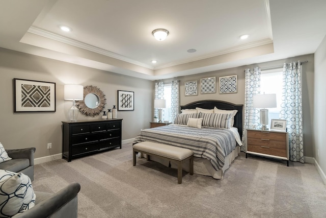 bedroom with carpet floors, a tray ceiling, and multiple windows