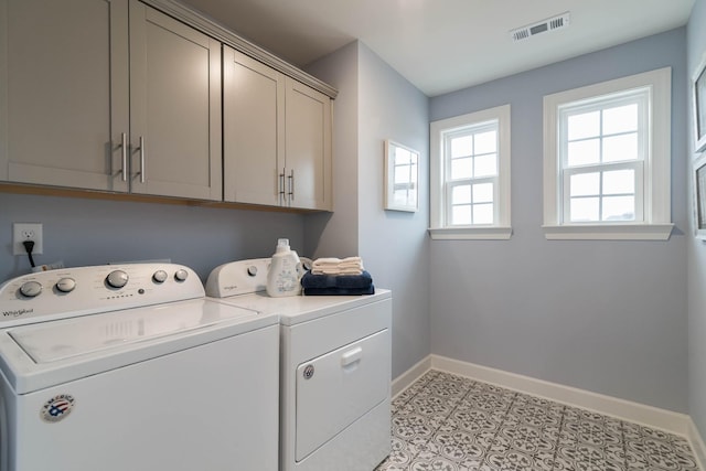 laundry area featuring cabinets, washing machine and dryer, and light tile patterned flooring