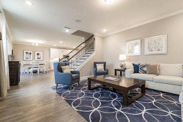 living room featuring a chandelier, wood-type flooring, and crown molding