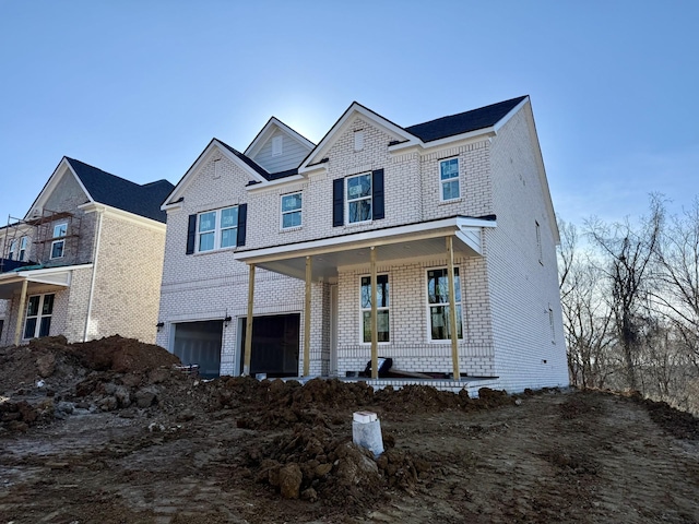 view of front of property featuring covered porch and a garage