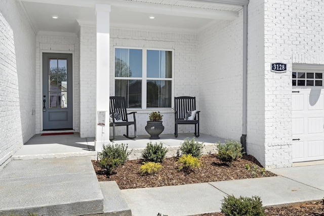 doorway to property with a garage and covered porch