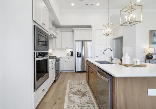 kitchen featuring visible vents, ornamental molding, an inviting chandelier, stainless steel appliances, and a sink