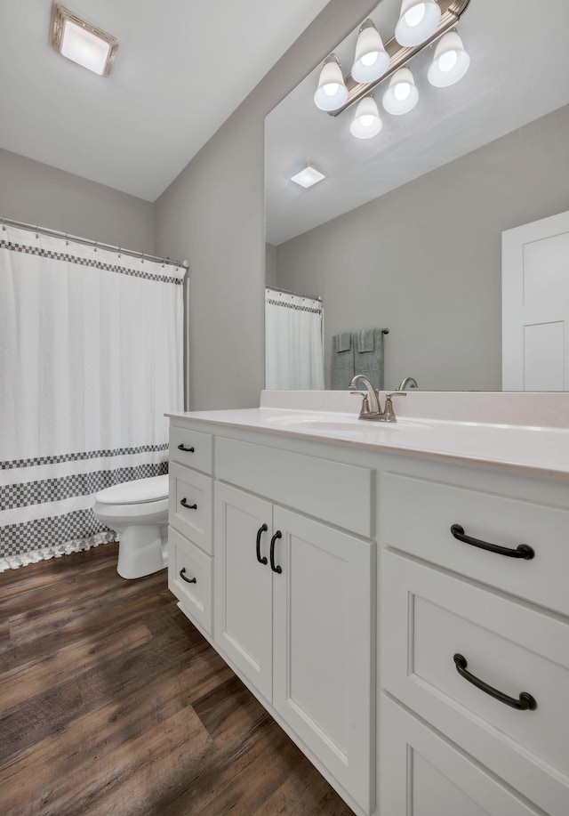 bathroom featuring wood-type flooring, vanity, and toilet