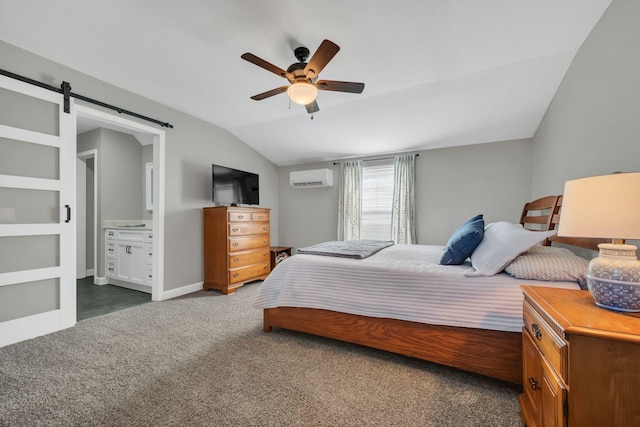 bedroom with lofted ceiling, ensuite bath, a wall unit AC, dark carpet, and a barn door