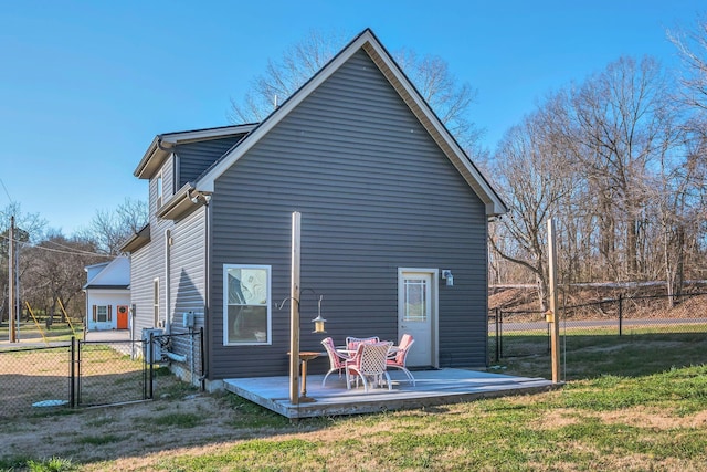 rear view of property featuring a deck and a lawn