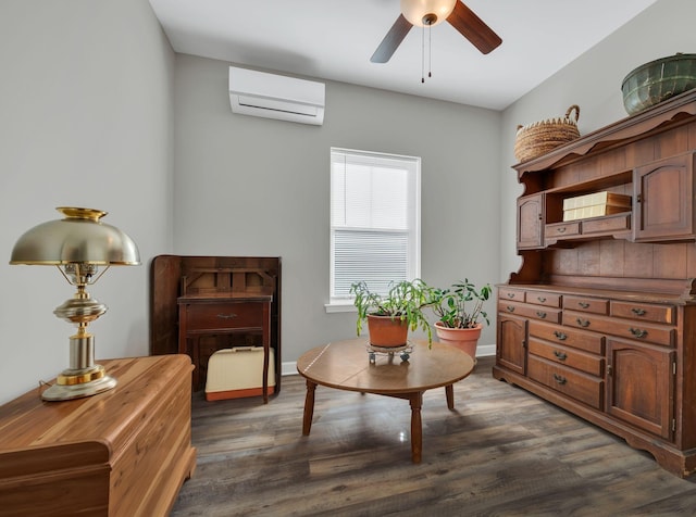 sitting room featuring dark hardwood / wood-style floors, ceiling fan, and an AC wall unit