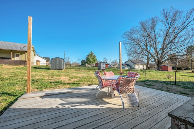 wooden terrace featuring a storage unit and a lawn