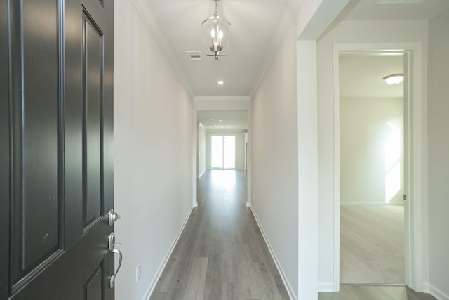 hallway featuring light hardwood / wood-style floors and crown molding