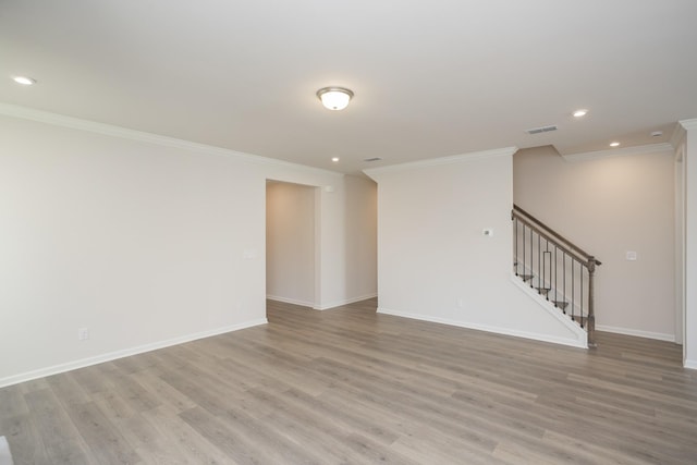 empty room with light hardwood / wood-style flooring and crown molding