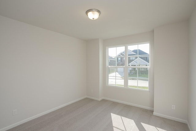 spare room featuring light colored carpet