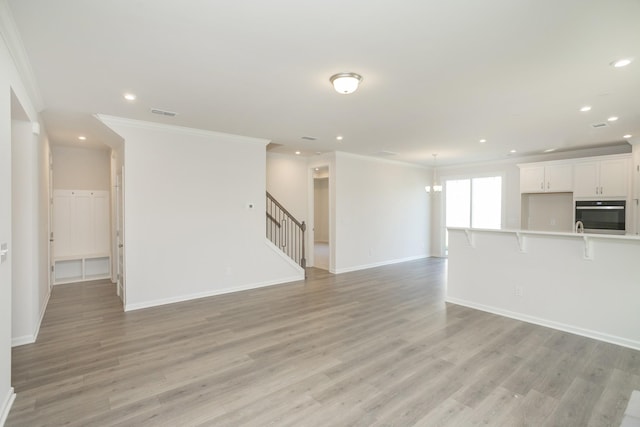 unfurnished living room featuring light hardwood / wood-style floors and ornamental molding