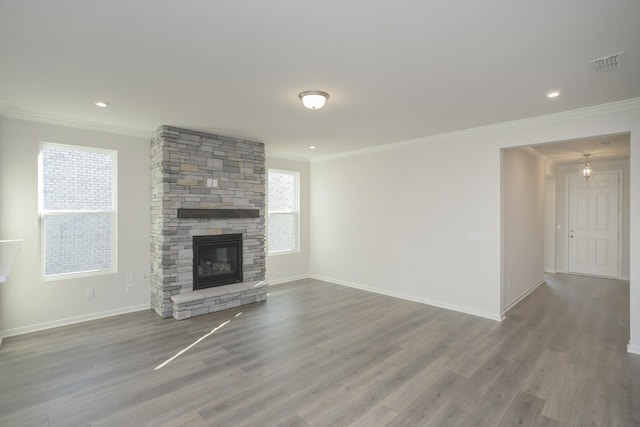 unfurnished living room featuring hardwood / wood-style flooring, a stone fireplace, and ornamental molding