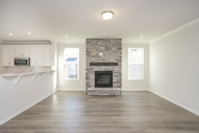 unfurnished living room featuring a fireplace, dark hardwood / wood-style floors, and ornamental molding