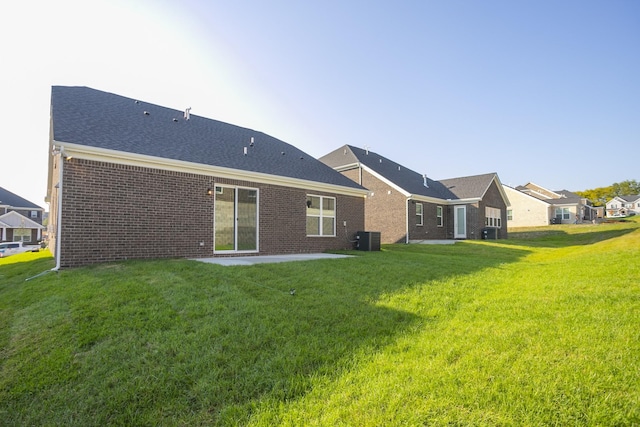 rear view of property featuring a yard and central AC