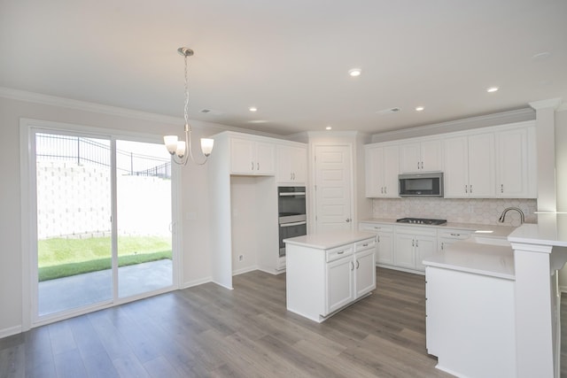 kitchen featuring white cabinetry, hanging light fixtures, and ornamental molding