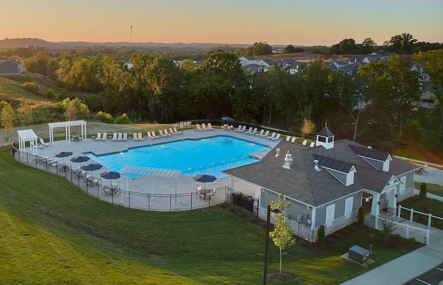 pool at dusk with a patio, a yard, cooling unit, and a pergola