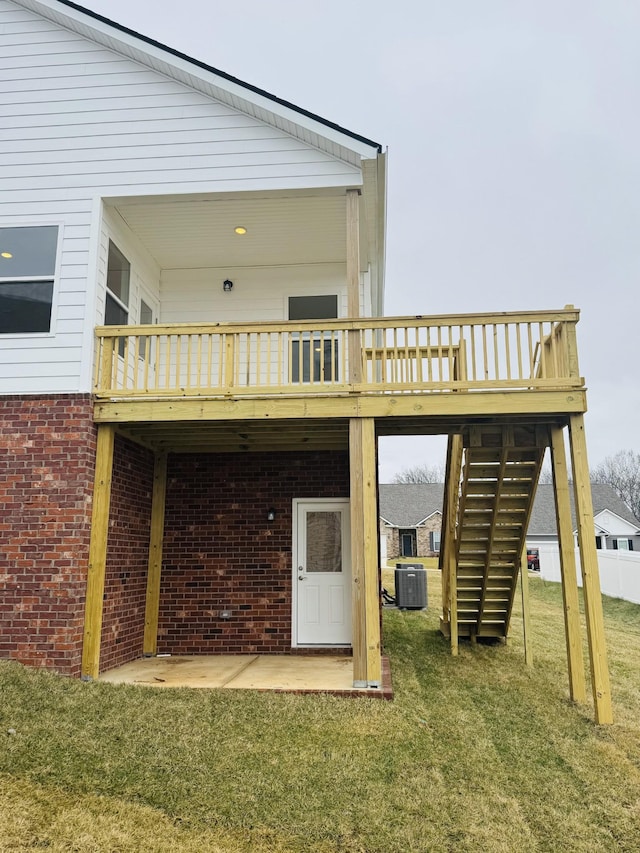 rear view of property featuring a wooden deck, a yard, a patio area, and central AC