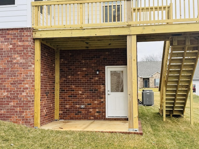 property entrance with a lawn, a patio area, and central air condition unit