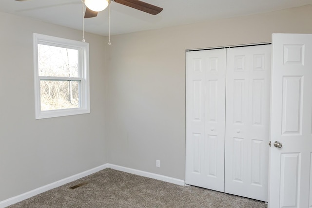 unfurnished bedroom featuring carpet flooring, ceiling fan, and a closet