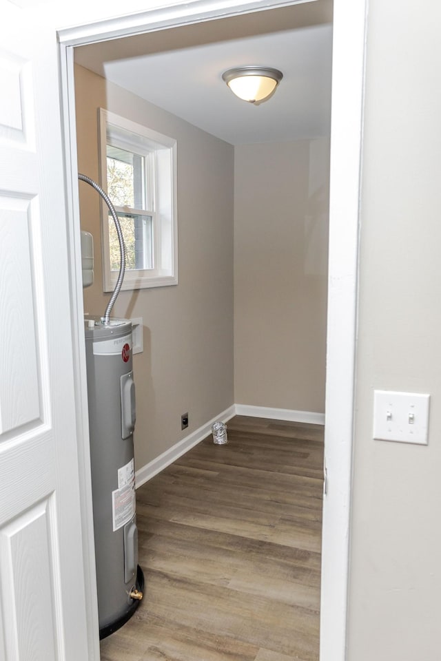 laundry room featuring hardwood / wood-style floors and water heater