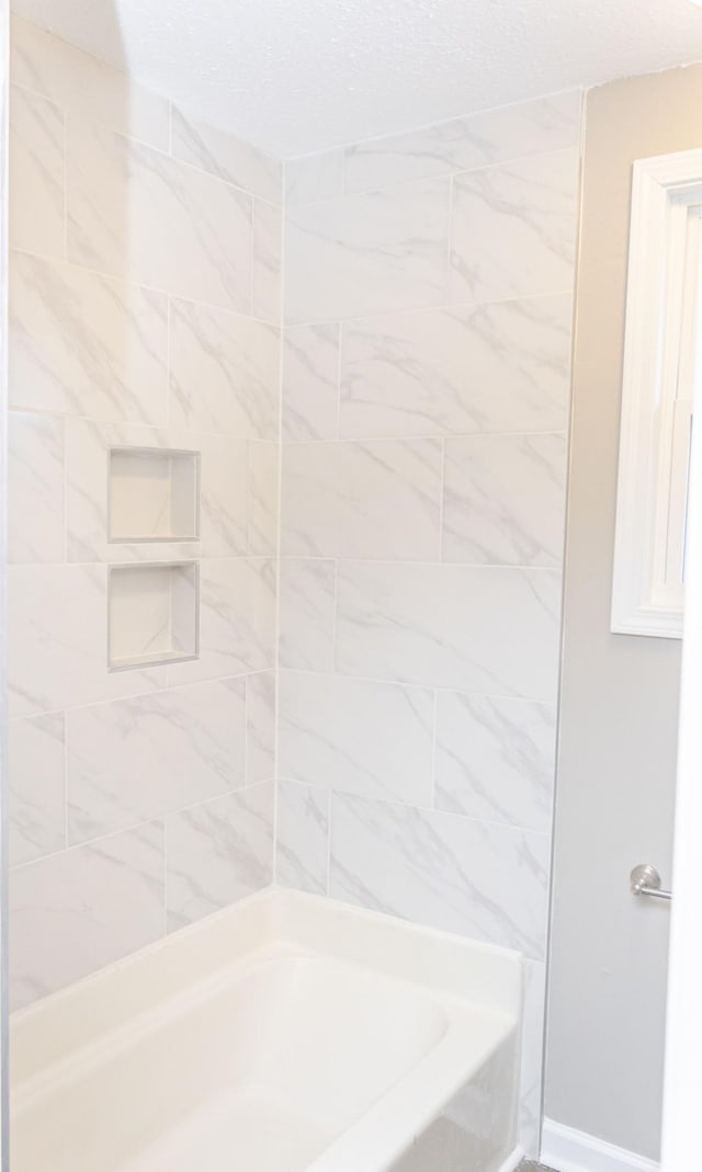 bathroom featuring tiled shower / bath