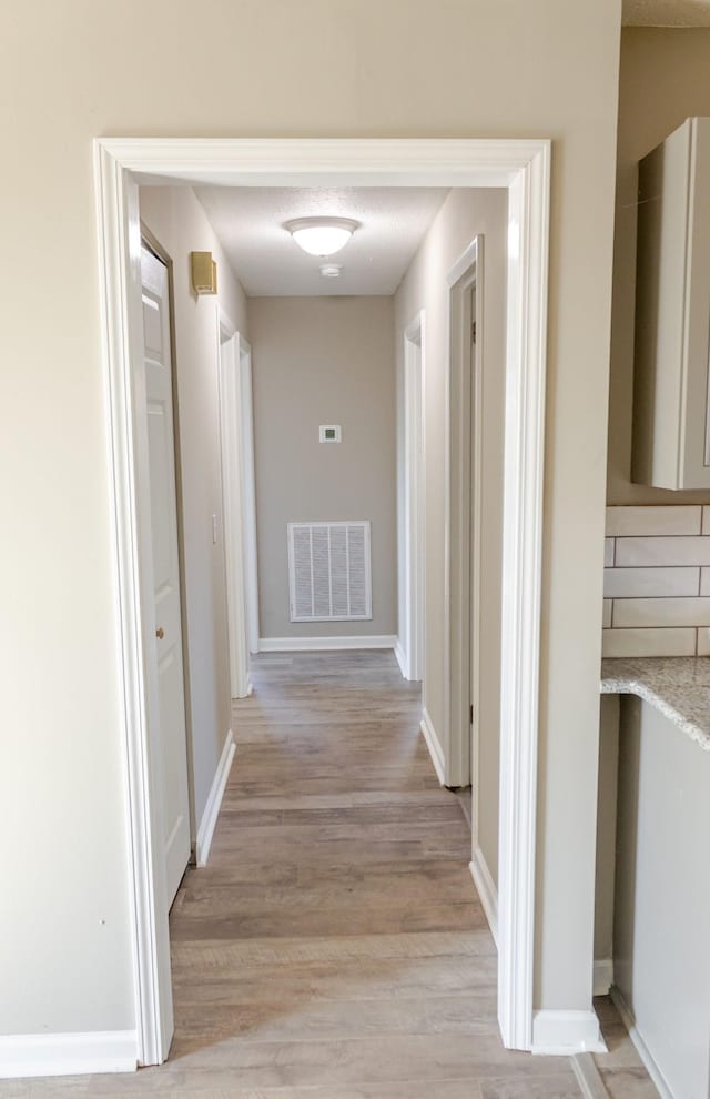 corridor with light hardwood / wood-style floors