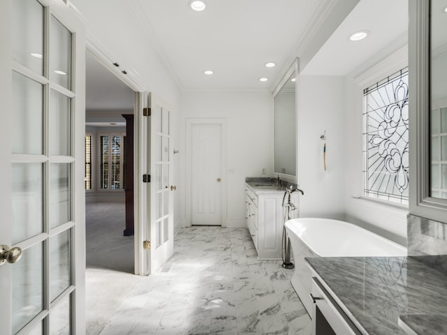 bathroom with vanity, a tub to relax in, and ornamental molding