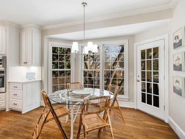 dining room with hardwood / wood-style flooring, plenty of natural light, and an inviting chandelier