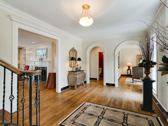 corridor featuring crown molding, built in features, and dark hardwood / wood-style floors