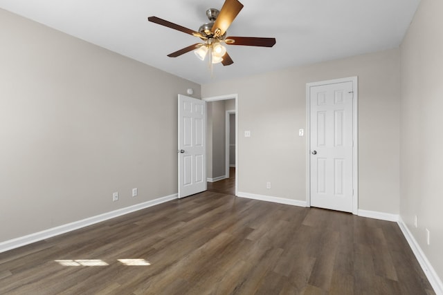 unfurnished bedroom with ceiling fan and dark wood-type flooring