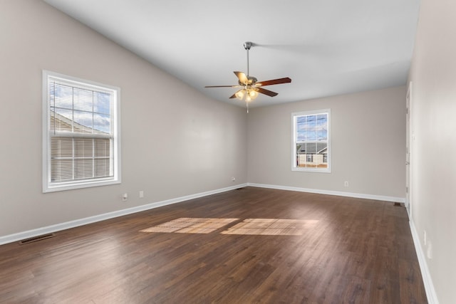 unfurnished room with ceiling fan, dark wood-type flooring, a wealth of natural light, and vaulted ceiling