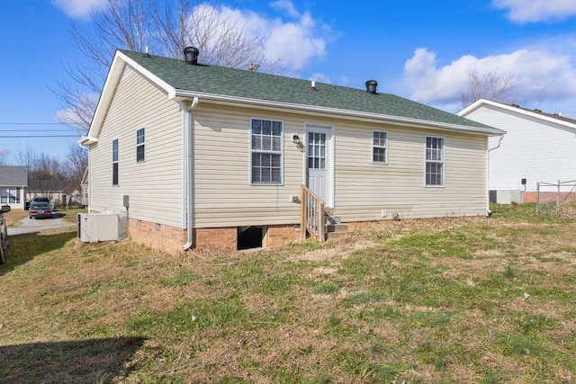 back of house with central AC and a lawn