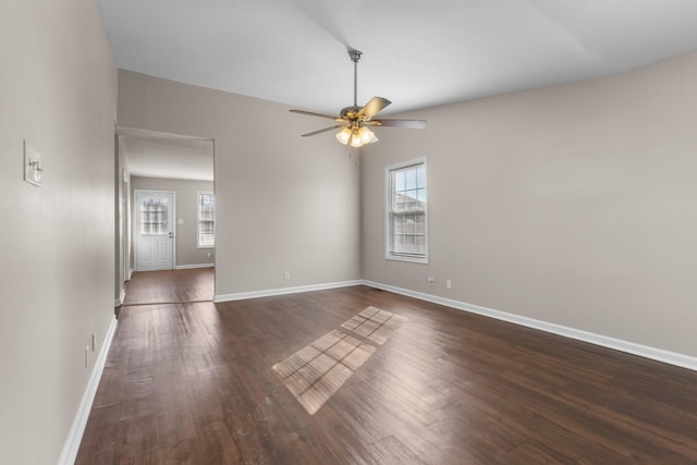 empty room with plenty of natural light, ceiling fan, and dark hardwood / wood-style floors