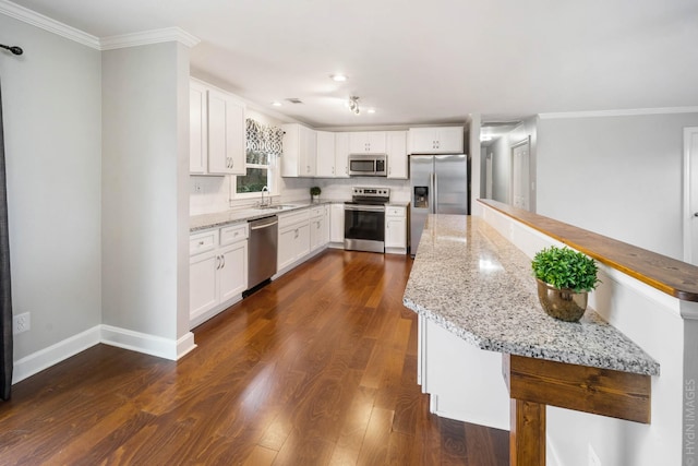 kitchen with white cabinetry, dark hardwood / wood-style flooring, light stone countertops, and appliances with stainless steel finishes