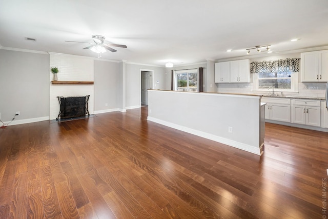 kitchen featuring white cabinetry, dark hardwood / wood-style floors, backsplash, and crown molding