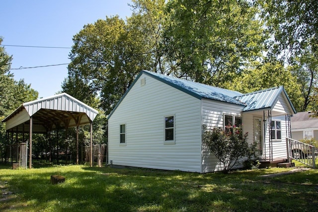 view of side of property with a carport and a yard