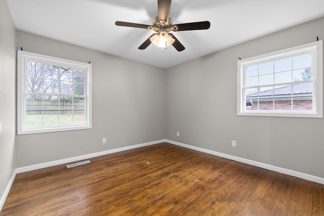 spare room with dark hardwood / wood-style flooring and ceiling fan